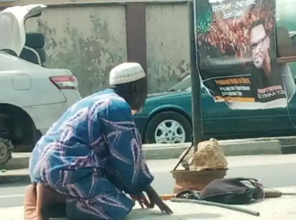Muslim man pictured praying in front a church banner